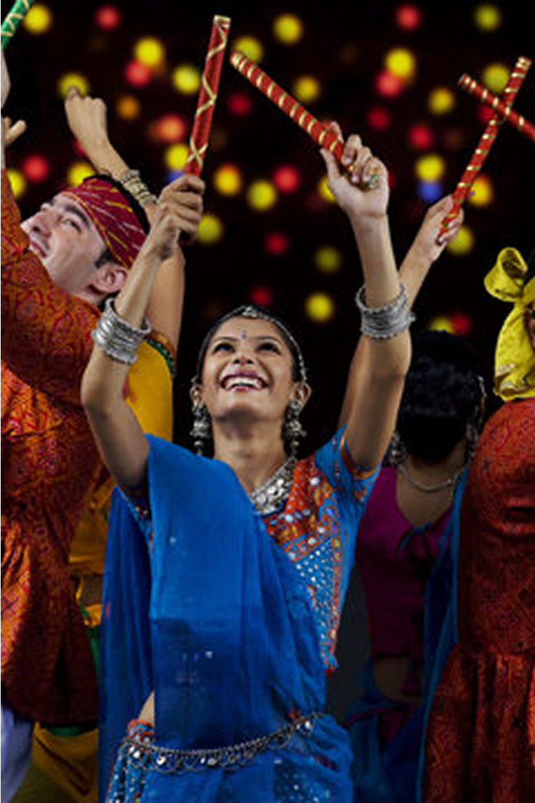 Woman in traditional Gujarati jewelry holding Dandiya sticks