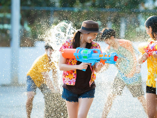 People celebrating Songkran with water guns and splashes